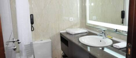 Une salle de bain avec des toilettes, un lavabo et un miroir.