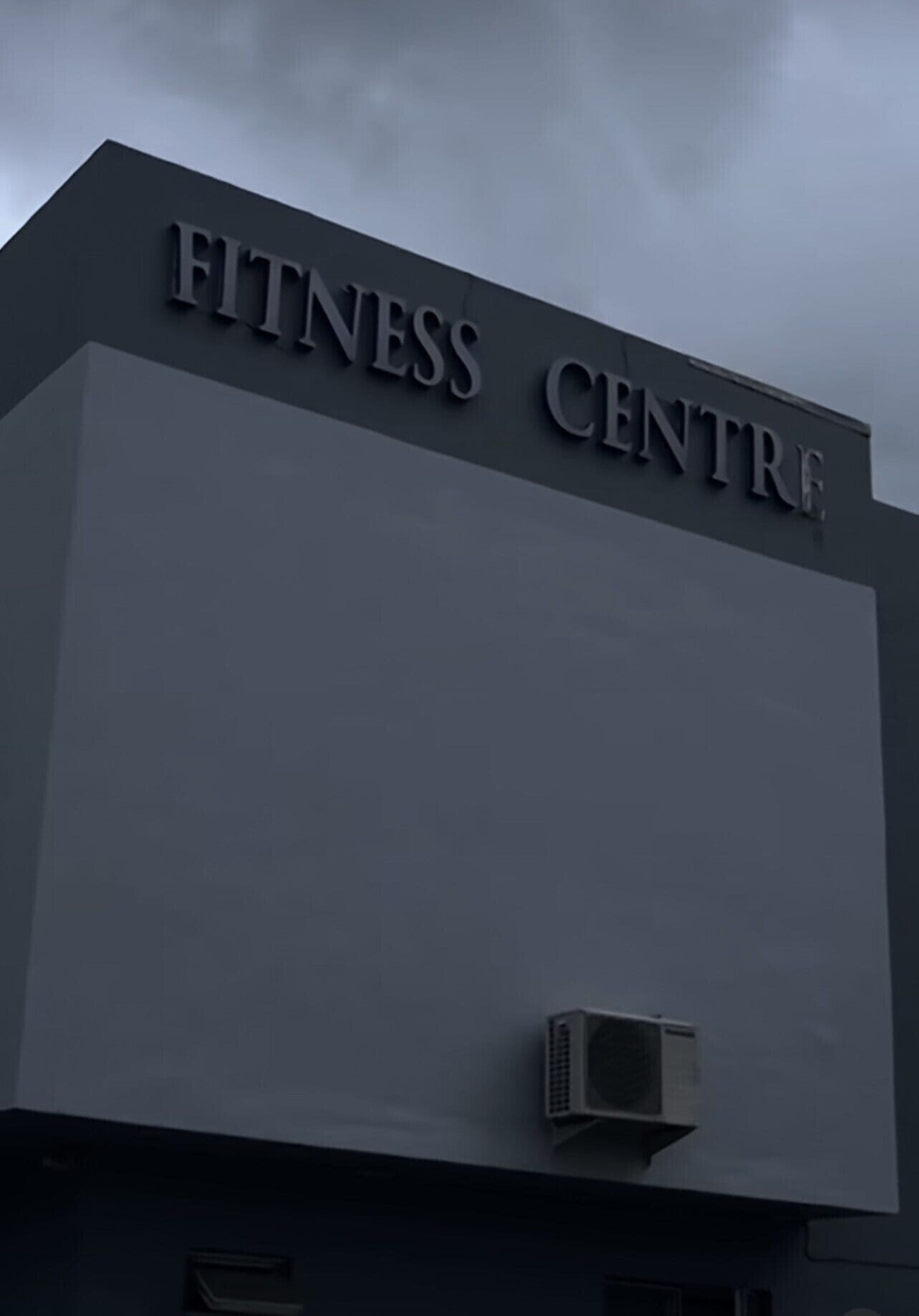 Een gebouw met een bord waarop staat 'FITNESS CENTRE'.