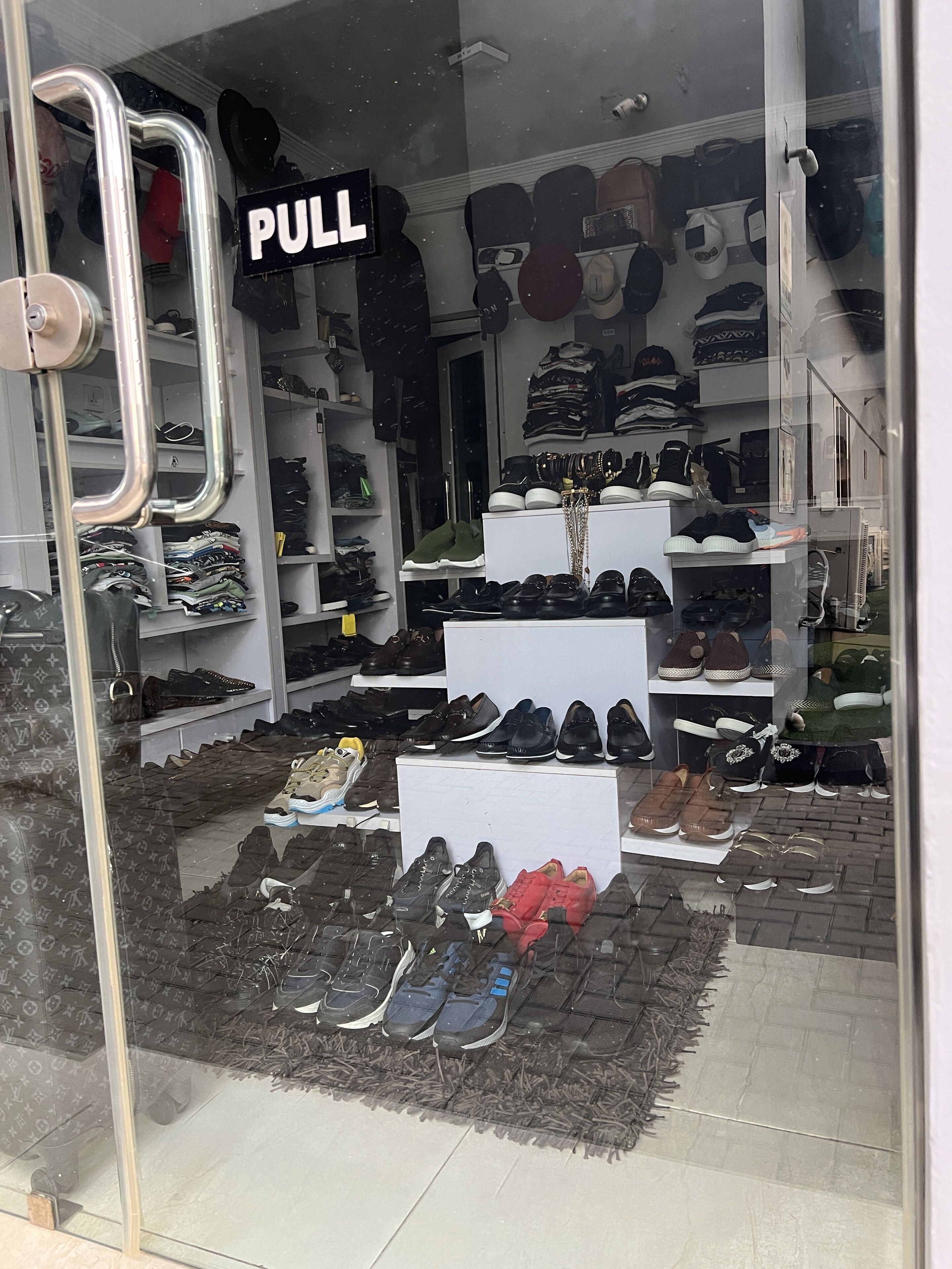 A shoe store with a 'PULL' sign, various shoe displays, and a 'PULL' sign on the door.