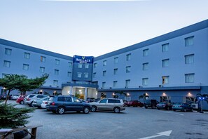 A hotel with a parking lot full of cars, a sign reading "Rollace Hotel", and a building with multiple windows. - Rollace Hotel Lagos INTL (Lagos)