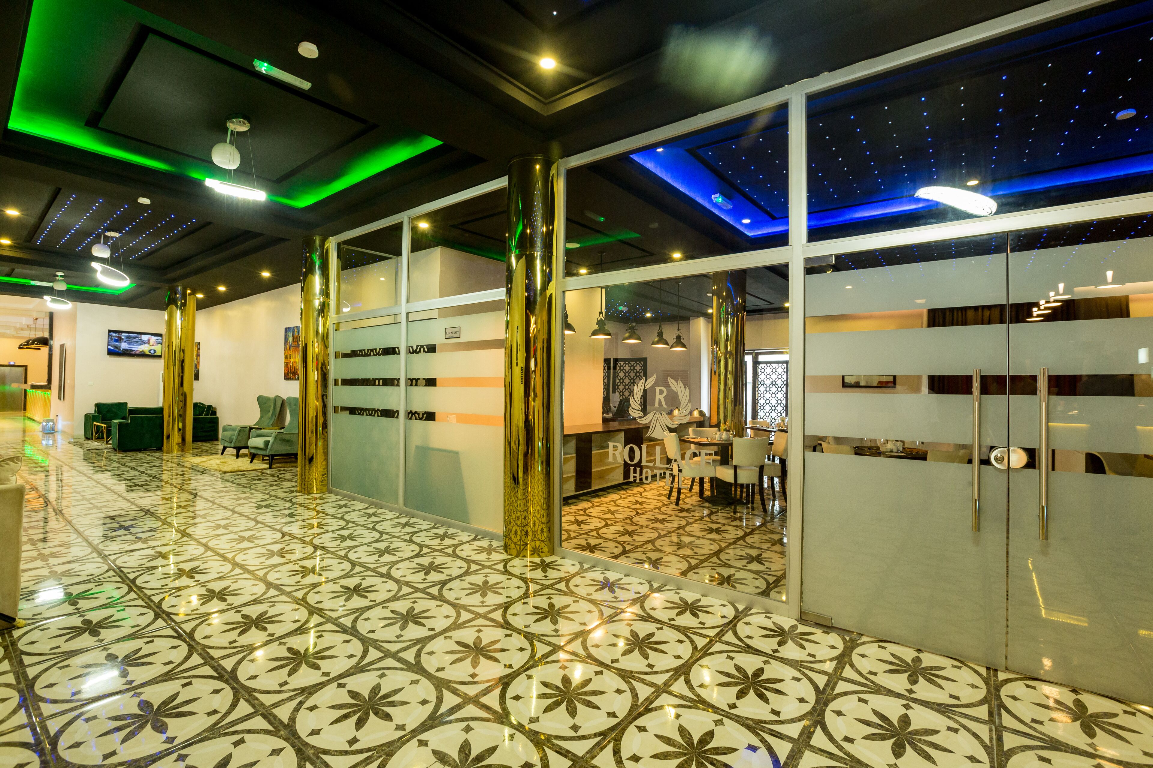 A hotel lobby with a patterned floor, modern furniture, and a starry ceiling design.