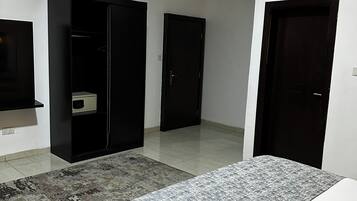 Un dormitorio con una cama, un armario y una puerta.