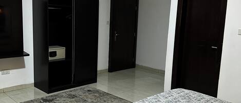 A bedroom with a bed, a wardrobe, and a door.