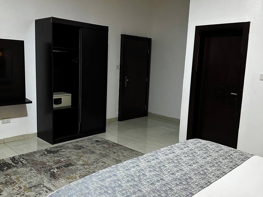 Un dormitorio con una cama, un armario y una puerta.