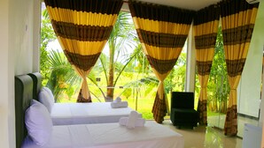 A hotel room with two beds, a chair, and a view of greenery outside. - Rivonway Hotel Polonnaruwa (Giritale)