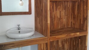 Ein Badezimmer mit einem Holzbadezimmer, einem weißen Waschbecken und einem Spiegel.