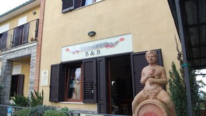 Un edificio con un cartel que dice "MARIANI B&B" y una estatua de un ángel frente a él.