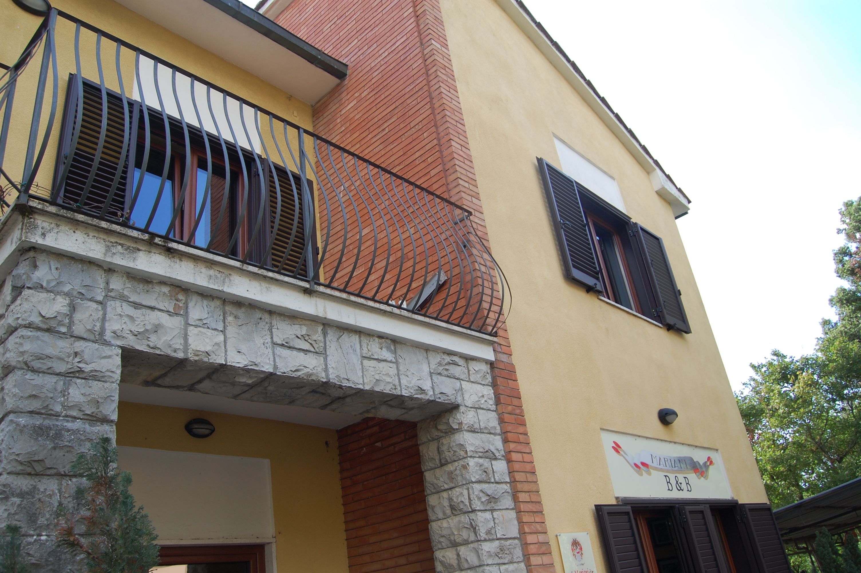 A building with a stone facade, a yellow exterior, and a sign reading "B&B".