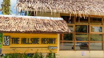 Experience a tropical ambiance at The Hillside Resort, where a thatched roof and simple layout create a peaceful retreat.