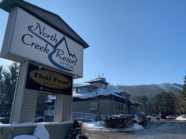 A North Creek Resort sign with a Thai Food restaurant below it.
