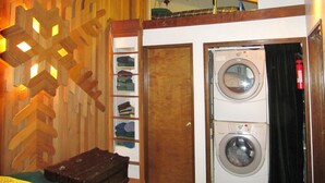 A laundry room with a washing machine and dryer, wooden wall decor, and a shoe rack. - Prime Mt. Hood/Government Camp Loop Condo Background Beautiful 11,230 ft Mt Hood (Government Camp)