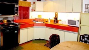 A compact kitchen with white cabinets, a red countertop, a black stove, and a microwave. - Prime Mt. Hood/Government Camp Loop Condo Background Beautiful 11,230 ft Mt Hood (Government Camp)