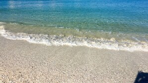 Ein Strand mit klarem Wasser und Kiesstrand.