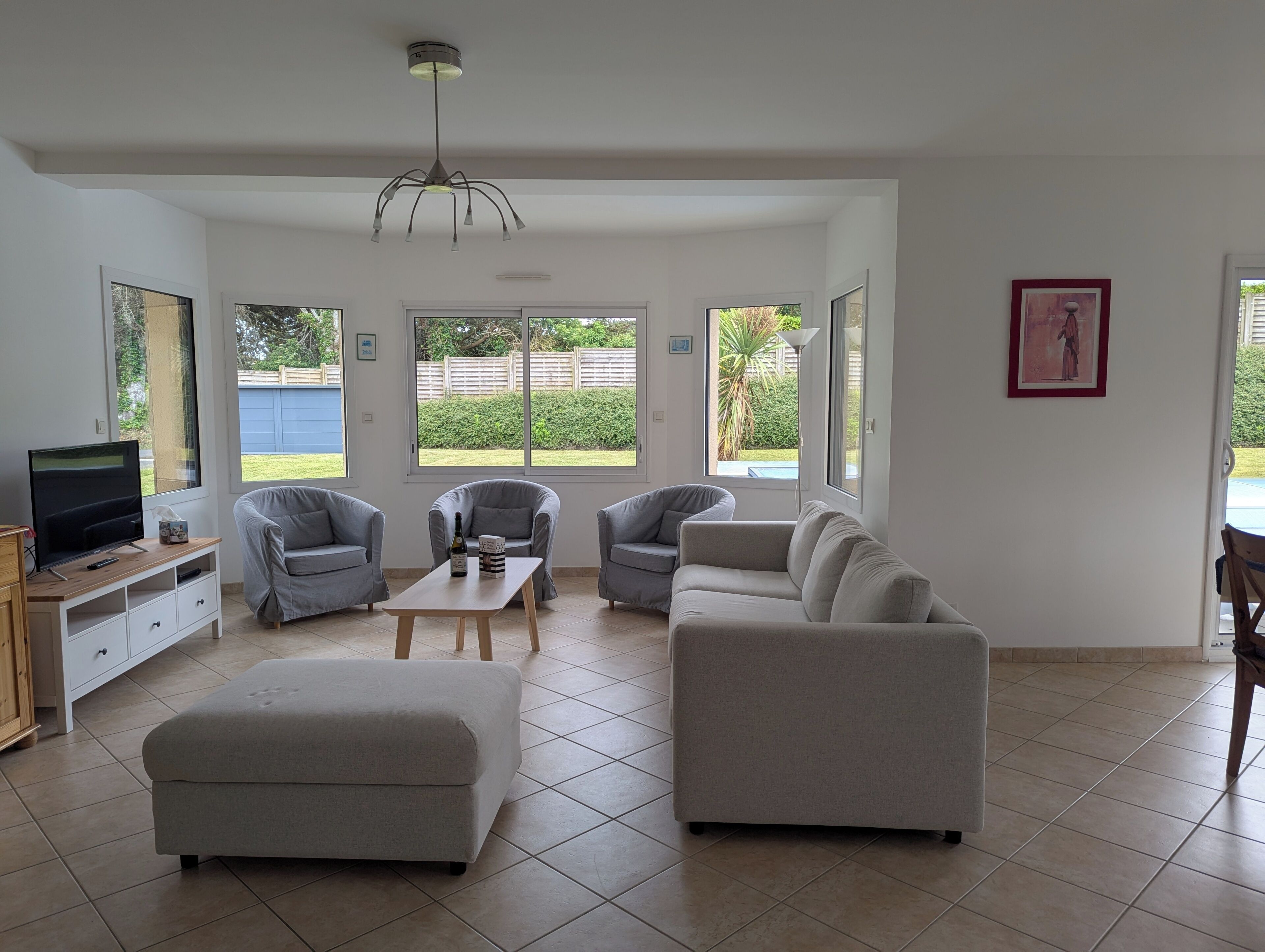 Ein geräumiges Wohnzimmer mit Fernseher, Sofas und einem Couchtisch.