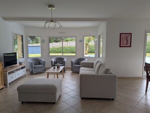 A spacious living room with a television, sofas, and a coffee table.