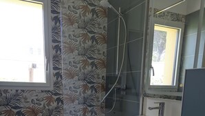 Een badkamer met een douche, wastafel en toilet.