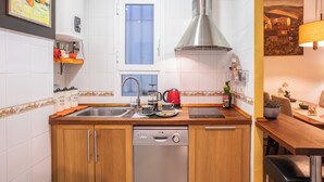 A modern kitchen with a dishwasher, double sink, and a window. - Lovely apartment in the historic district of Seville (+ WiFi & AC) (Sevilla)