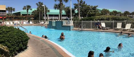A swimming pool with a 3 FT depth marker, surrounded by palm trees and lounge chairs.