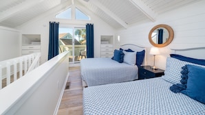 A bedroom with two beds, a ceiling fan, a round mirror, and a view of the outside. - Bright Decor! 3 BR/3 BA Villa; Pools/Beach Nearby! Amenity access included! (Seabrook Island)