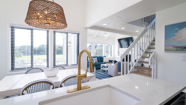 A modern kitchen with a white countertop, gold faucet, and a woven pendant light. - Bright Decor! 3 BR/3 BA Villa; Pools/Beach Nearby! Amenity access included! (Seabrook Island)
