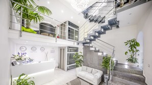 Un interior moderno con una recepción, una escalera y una zona de estar.