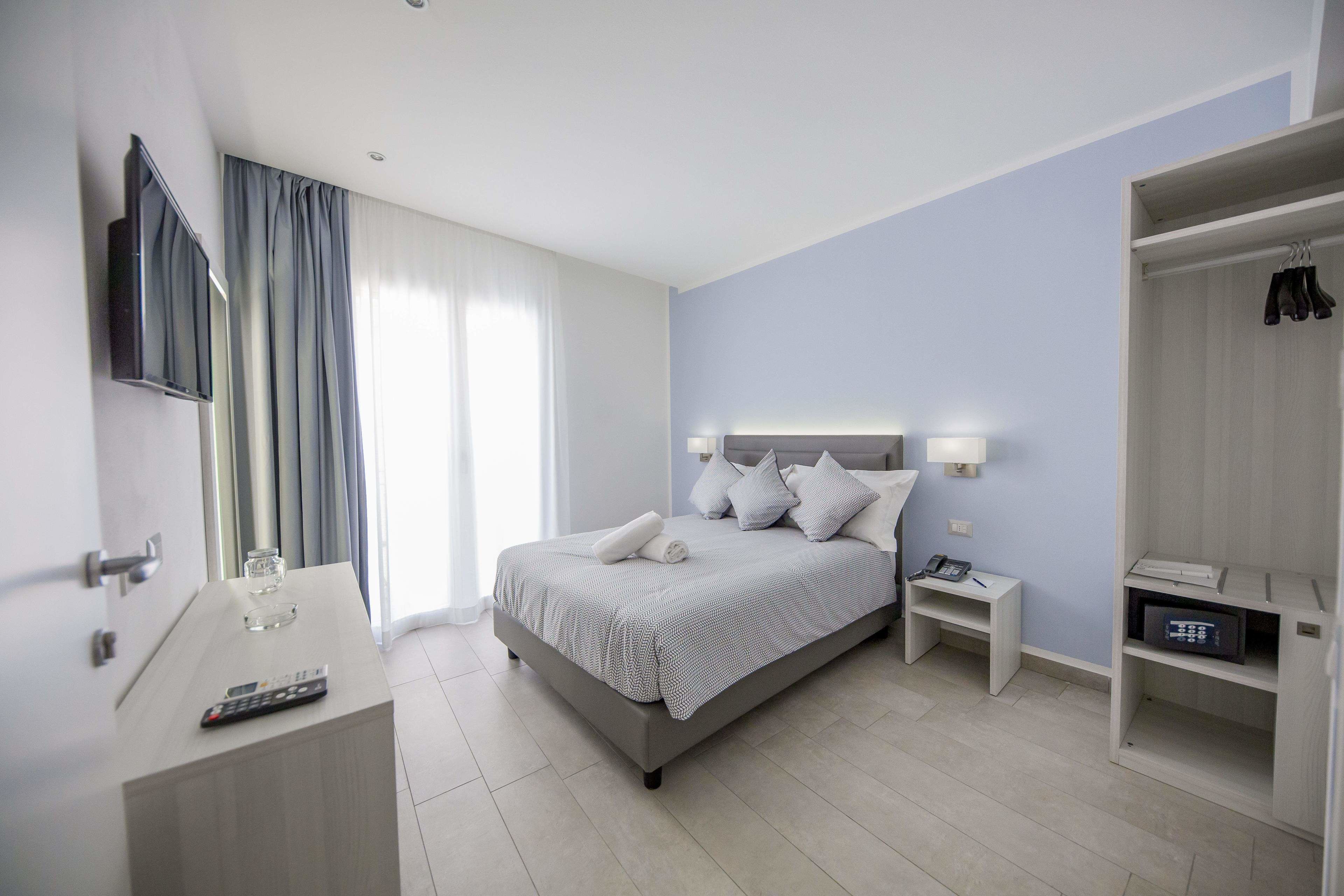 Un dormitorio moderno con cama, mesita de noche y armario.