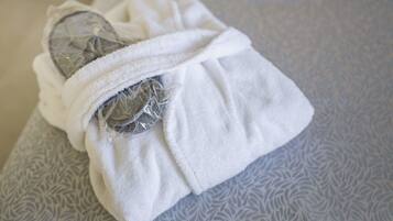 A white towel wrapped around a rolled-up item on a patterned surface.
