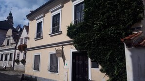 A building with a balcony, a door, and a window with a sign. - Pension PREMIUM (Cesky Krumlov)