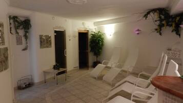 Relax in a serene space with a minimalist design, featuring a waiting area with white chairs and a small table with a potted plant.