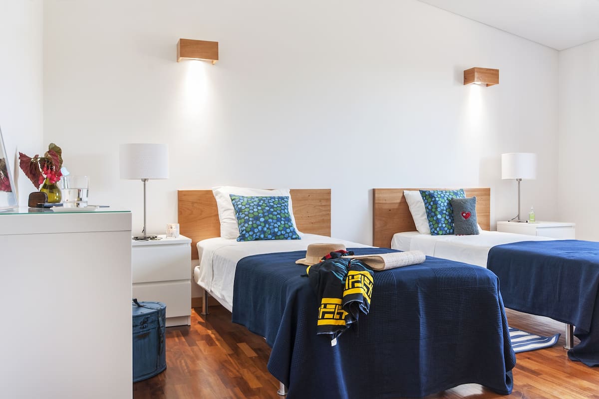 A hotel room with two beds, wooden headboards, and bedside lamps.