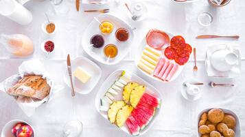 A breakfast spread with various foods and drinks on a table.