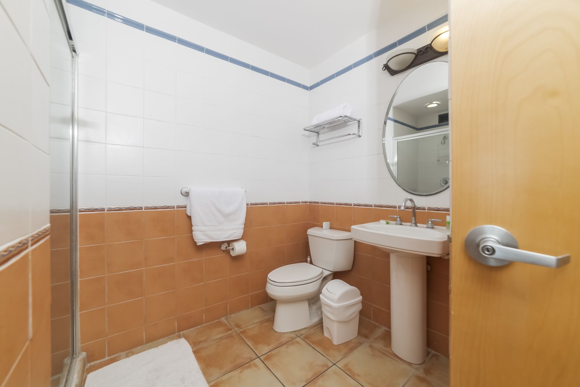 Un baño con ducha, inodoro, lavabo y espejo.