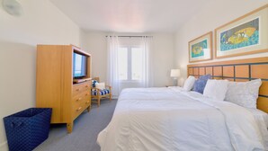 Ein Hotelzimmer mit Bett, Fernseher, Schreibtisch und Stuhl.