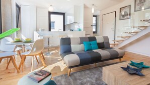 A modern living room with a sofa, chairs, a coffee table, and a dining area with a table and chairs.