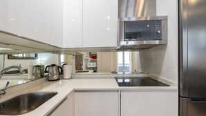 Une cuisine moderne équipée d’appareils électroménagers en acier inoxydable, d’un four à micro-ondes encastré et d’un évier.