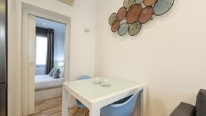 Une petite pièce moderne comprenant une table et des chaises, un canapé et un élément décoratif mural.