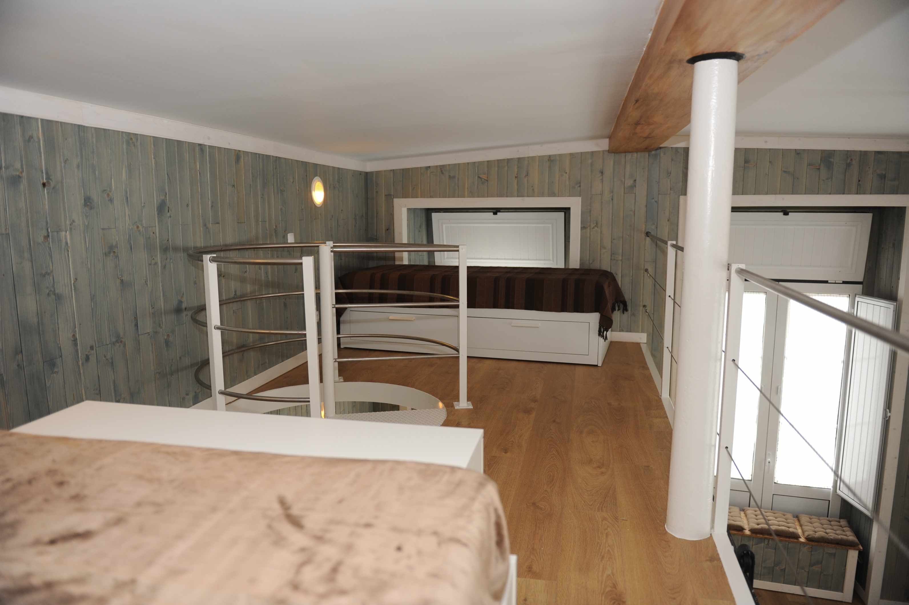 A bedroom with a bunk bed, a small table, and a window.