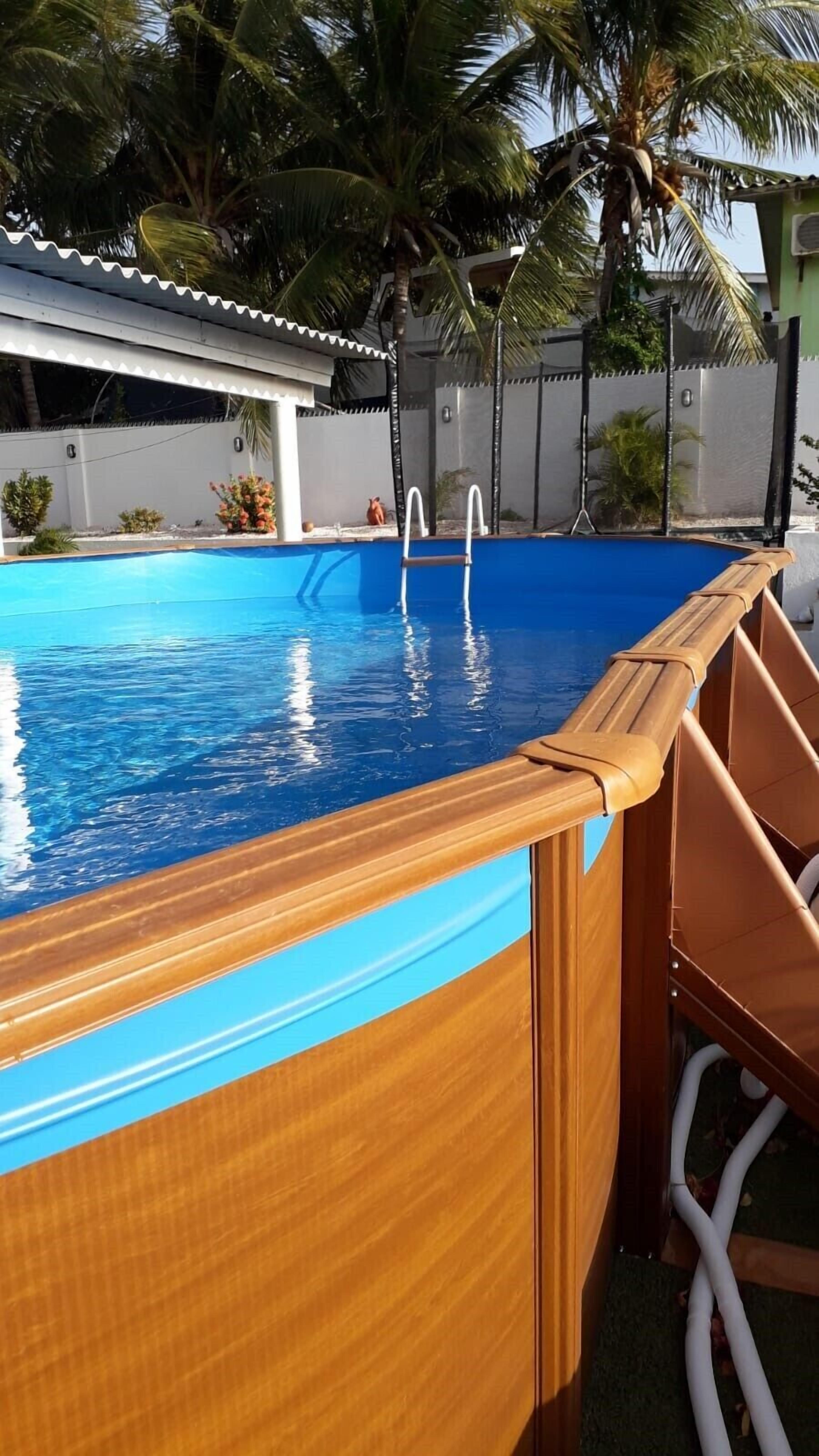 A swimming pool with a wooden deck and a ladder.