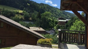 Une cabane en bois dotée d’un balcon donnant sur un paysage montagneux.