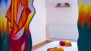 Ein Zimmer mit einem Bett, einem Heizkörper und einem Regal mit zwei Dekorationen.