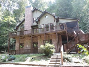 A two-story house with a balcony, a chimney, and a staircase leading to the upper level.