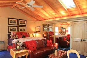 Relax in comfort with a cozy sofa, wooden side table, and inviting bed.