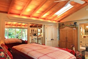 Relax in this serene bedroom with a large bed and a wardrobe, featuring a mirror above.