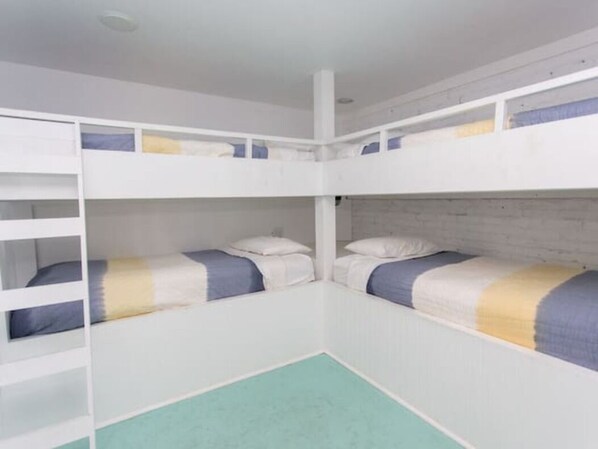 A room with bunk beds, a white ceiling, and a light-colored floor.