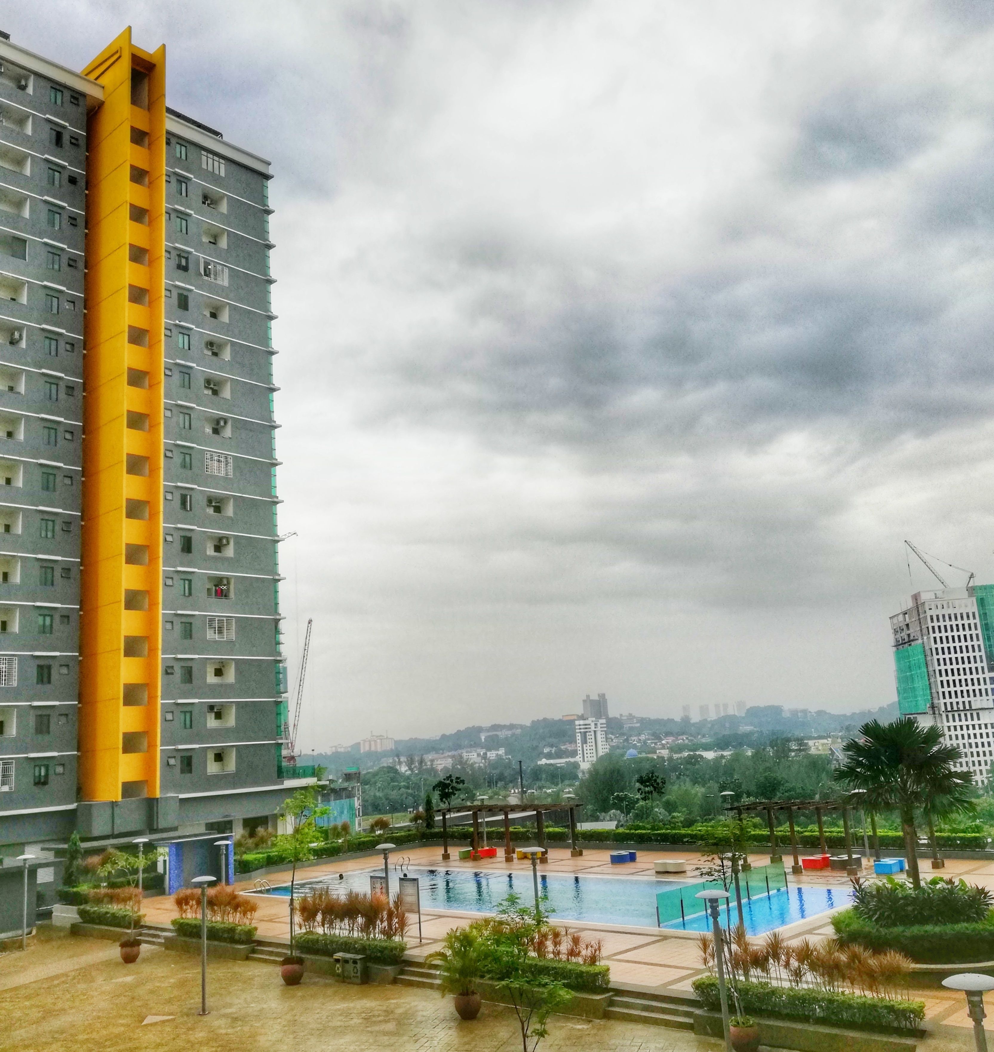 Edificio residencial con zona de piscina, que incluye una alberca y mobiliario exterior.