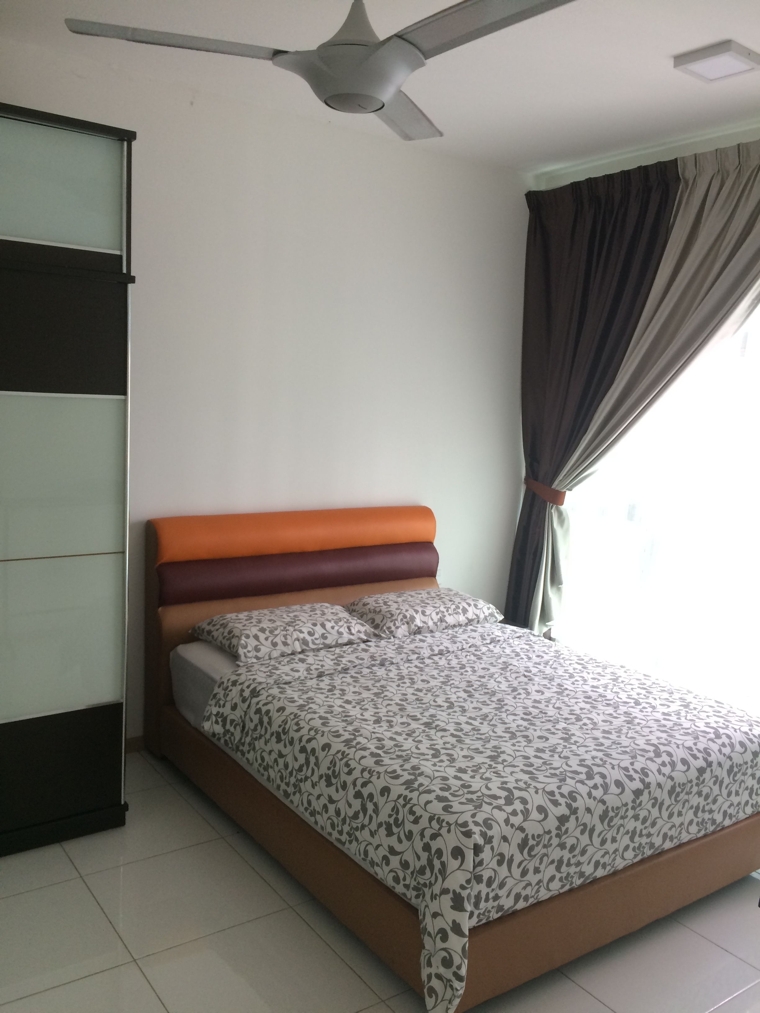 A bedroom with a bed, a ceiling fan, a window with curtains, and a wall unit.