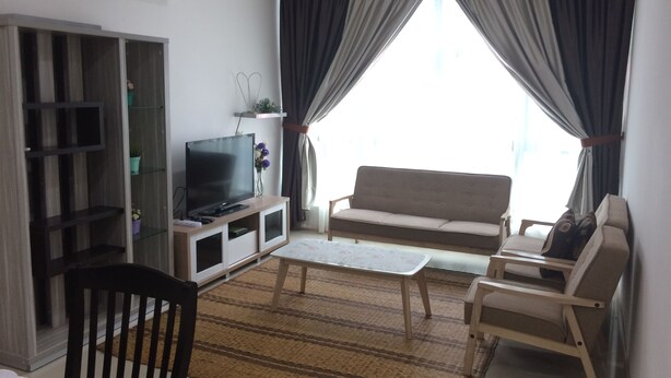 A living room with a TV, sofa, chairs, and a window with curtains. - Lawang Suite 2 Bedroom Standard Apartment 3 (Shah Alam)