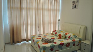A bedroom with a bed, a nightstand, a lamp, and a window with curtains. - Lawang Suite 2 Bedroom Standard Apartment 3 (Shah Alam)
