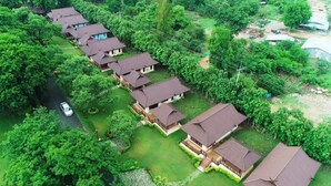 A residential area with multiple houses, each with a distinct architectural style featuring sloped roofs and wooden balconies. - Doi Inthanon Riverside Resort (Wiang Nong Long)