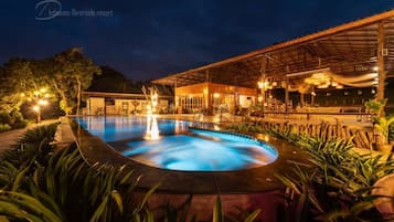 Una piscina al aire libre, sillones reclinables de piscina